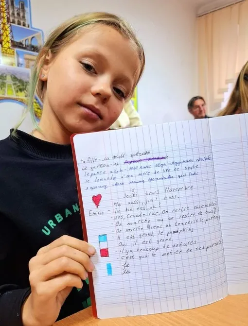 Une élève de Bérezné montre son cahier de français