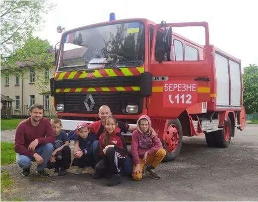 Des enfants de Bérezné devant le camion de pompiers offert par Ars-sur-Formans