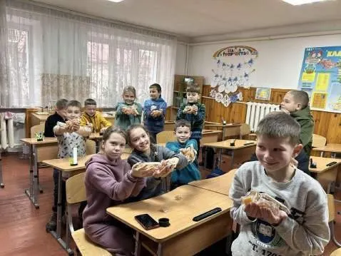 Des élèves avec les friandises apportées par le convoi